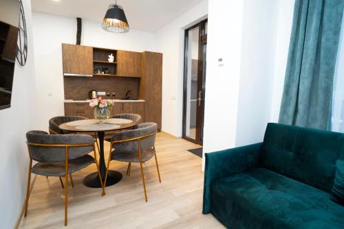 - un salon avec un canapé vert, une table et des chaises dans l'établissement Central Station Apartment No1, à Kaunas