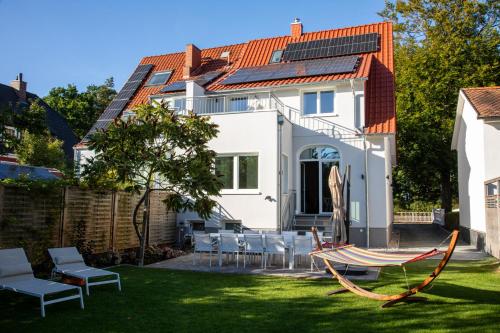 une maison avec un hamac dans la cour dans l'établissement Ferienhaus Luv und Meer, à Warnemünde