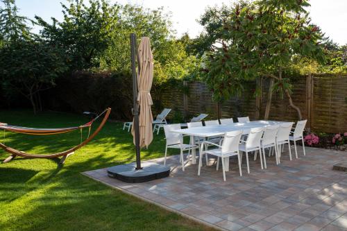 - une table, des chaises et un parasol dans le jardin dans l'établissement Ferienhaus Luv und Meer, à Warnemünde