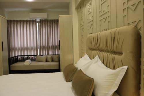 a bedroom with a bed and a couch and a window at Amman Trail Hotel & Studios in Amman