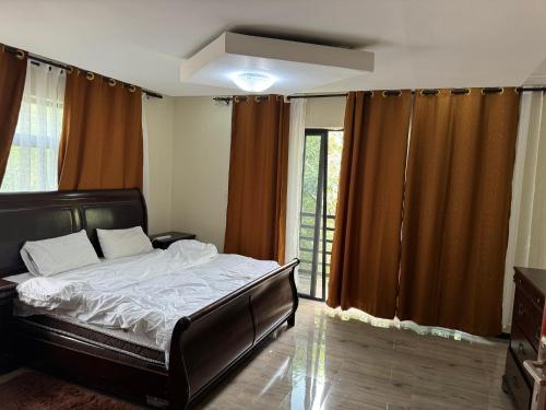 een slaapkamer met een bed en een groot raam bij Steady State Apartment 1 in Lusaka