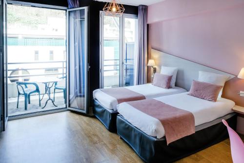 Cette chambre dispose de deux lits et d'un balcon. dans l'établissement Hôtel Sainte-Rose, à Lourdes