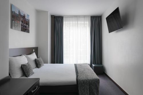 pokój hotelowy z łóżkiem i oknem w obiekcie Hotel City Garden Amsterdam w Amsterdamie