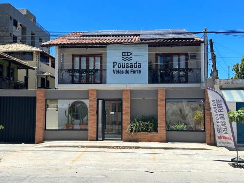 un edificio con un cartel en el costado en Pousada Velas do Forte, en Cabo Frío