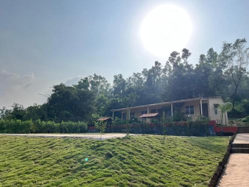 un edificio con un prato davanti di VRISA Mountain Retreat a Pune