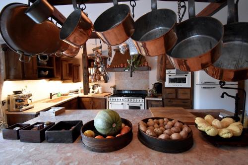 uma cozinha com tigelas de legumes, panelas e frigideiras em Reinado de Dom Dinis em Dornes