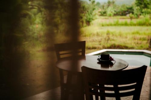 una mesa con dos sillas y una taza de café. en Sunrise Paradise Bali, en Karangasem