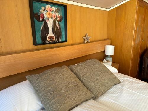 1 dormitorio con 1 cama con una pintura de una vaca en Alpina Boutique Hotel Ringgenberg - Adults only !, en Ringgenberg