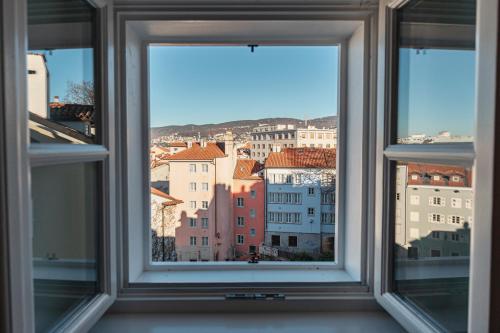 ein offenes Fenster mit Stadtblick in der Unterkunft Hurban Apartments Venezian in Triest