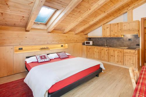 um quarto com uma cama grande e uma cozinha em Chalet Primula 14 em Santa Caterina Valfurva