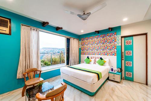 1 dormitorio con cama y ventana grande en Treebo Raval Resort with Valley View, en Panchgani