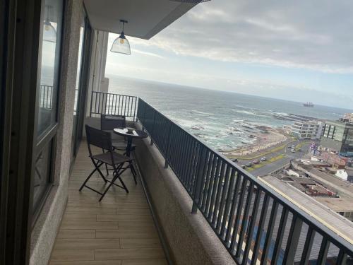 einen Balkon mit einem Stuhl und Meerblick in der Unterkunft Surf and Relax Apartment in Iquique