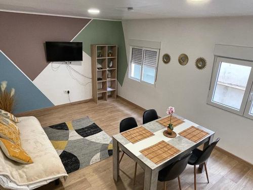 a living room with a table and a couch at BEL APPARTEMENT ROSES PLAGE in Roses