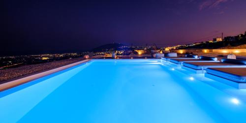 una piscina notturna con vista di Terra Blanca Suites a Imerovigli