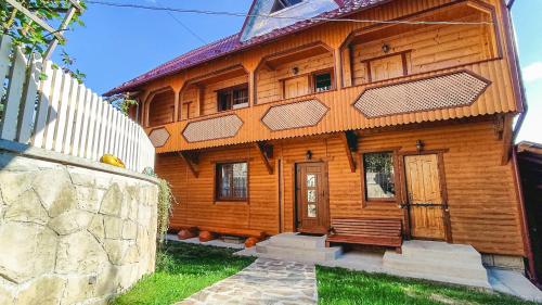 una casa de madera con una valla delante en Котедж Біля лісу, en Yaremche