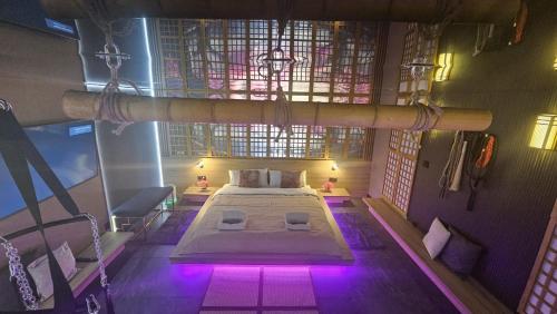 a bedroom with a bed with purple lights in it at Grey Aqua Secret Apartament in Gdańsk