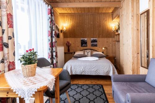 um quarto com uma cama, uma mesa e cadeiras em Willa u Jadzi em Zakopane