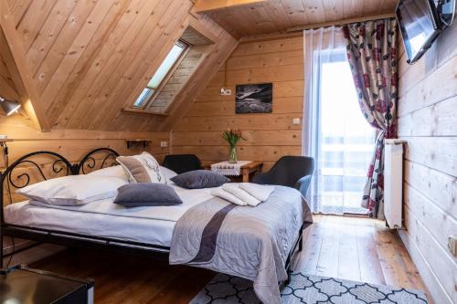 um quarto com uma cama num quarto com paredes de madeira em Willa u Jadzi em Zakopane