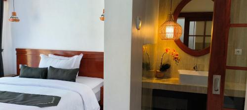 a bedroom with a bed and a mirror and a sink at ZiFa Mandalika in Kuta Lombok