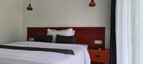 a bedroom with a large bed with a wooden headboard at ZiFa Mandalika in Kuta Lombok