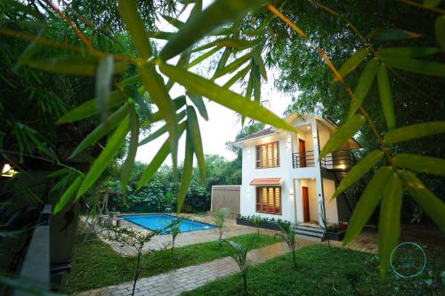 a house with a swimming pool in front of it at Le Eden Resort in Sultan Bathery