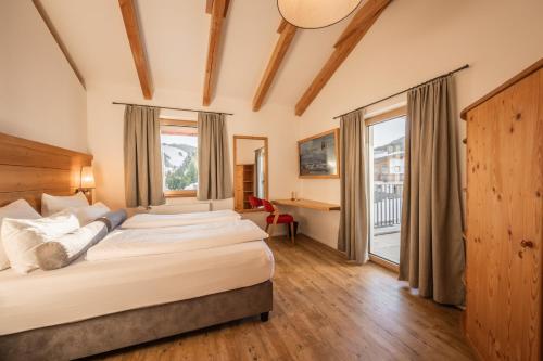 ein Schlafzimmer mit einem Bett und einem großen Fenster in der Unterkunft Löwen Chalets in Seefeld in Tirol