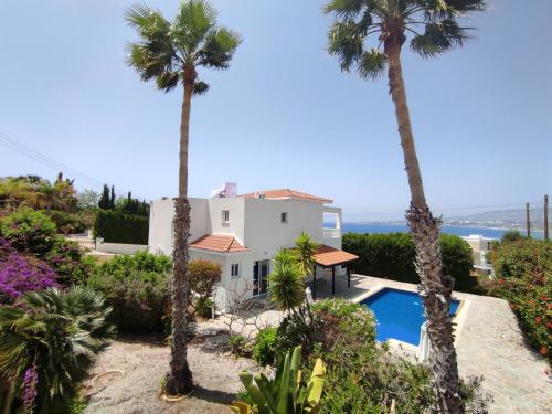 una villa con palme e piscina di Theo Sunset Bay Hotel a Paphos