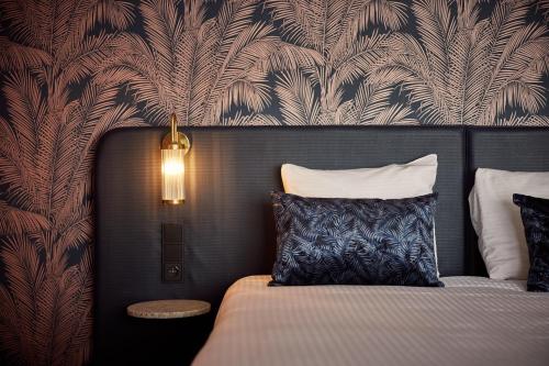 a bedroom with a bed with a black and white patterned wall at Van der Valk Hotel Brussels Airport in Diegem