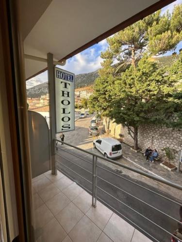 uma varanda com vista para um carro numa rua em THOLOS HOTEL em Delfoi