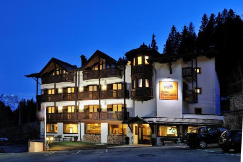 um grande edifício branco com luzes acesas em Hotel Montana em Madonna di Campiglio