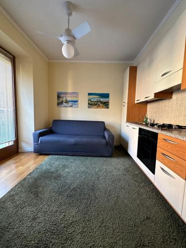 a living room with a blue couch in a kitchen at Apartment BelLenno in Lenno