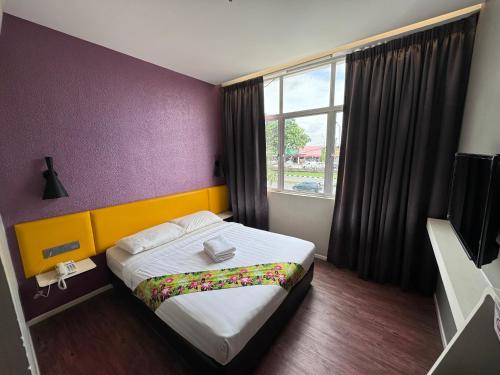 una camera d'albergo con letto e finestra di Win Win Boutique Hotel PD a Port Dickson