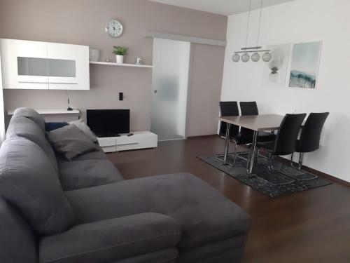 ein Wohnzimmer mit einem Sofa und einem Tisch in der Unterkunft Ferienwohnung Leithaberg in Eisenstadt