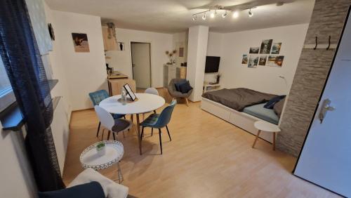 a living room with a table and chairs and a bedroom at Schöne Souterrain Wohnung (WLAN/Parken kostenlos) in Riegel