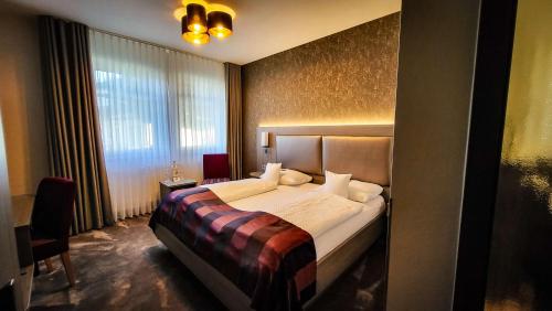 sypialnia z łóżkiem i dużym oknem w obiekcie Best Western Plus Hotel Willingen w mieście Willingen