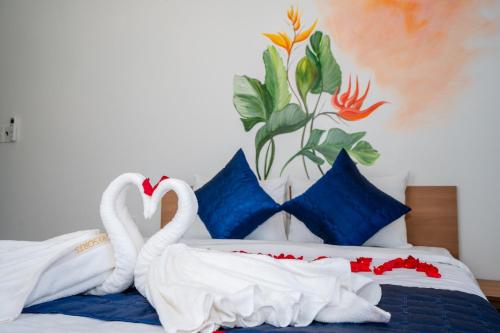 dos cisnes blancos están sentados en una cama en MONTANA HOMESTAY VUNG TAU, en Vung Tau