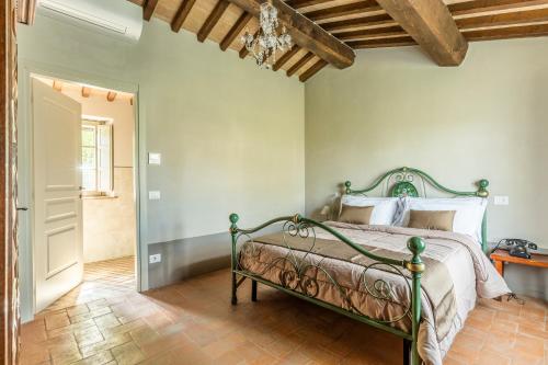 ein Schlafzimmer mit einem grünen Bett in einem Zimmer in der Unterkunft Agriturismo Merigge Wellness & Spa Montepulciano in Montepulciano