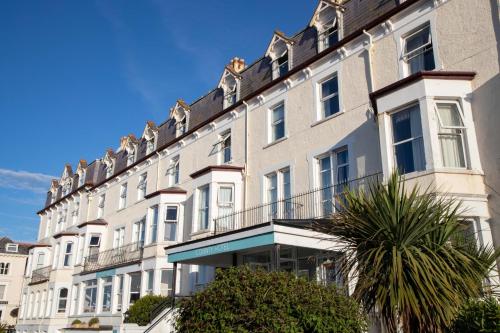 een groot wit gebouw met balkons in een straat bij The County Hotel in Llandudno