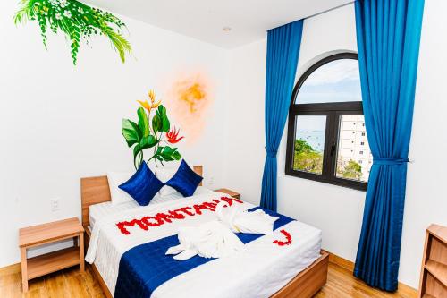 1 dormitorio con 1 cama grande y cortinas azules en MONTANA HOMESTAY VUNG TAU, en Vung Tau