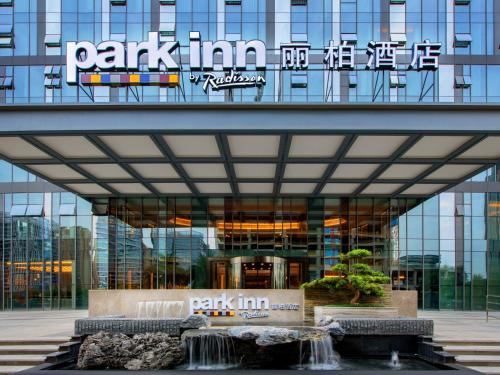 un edificio con una fuente de agua frente a él en Park Inn by Radisson Chengdu Sihe Metro Station Xinchuan, en Chengdú