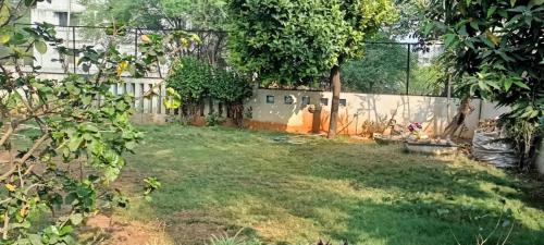 a backyard with a fence and a grass yard at Ram@nasik in Nashik