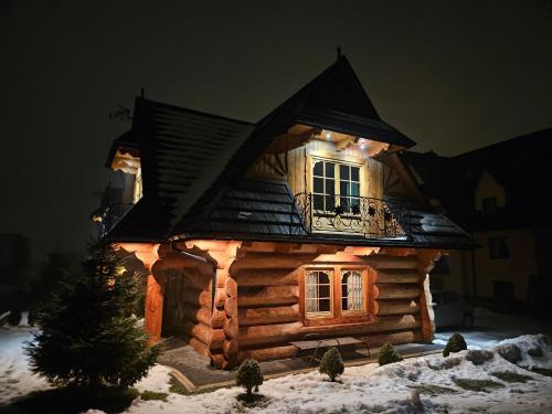 een blokhut met verlichting in de sneeuw bij Domek Góralski Amelka in Poronin