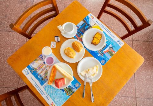 une table avec des assiettes de nourriture au-dessus dans l'établissement DiRoma Fiori Hotel - BVTUR, à Caldas Novas