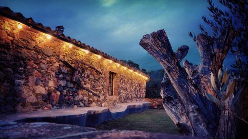 - un bâtiment en pierre avec des lumières sur le côté dans l'établissement Masia Can Bachs, à Sant Pere de Vilamajor