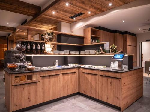 una cucina con armadi in legno e piano di lavoro di Central Hotel & Apart mit Landhaus Central a Fügen