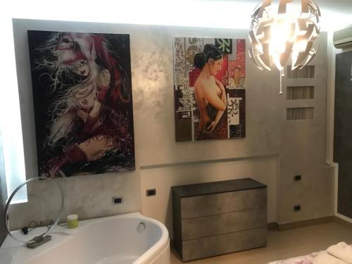 a bathroom with two posters on the wall and a tub at La casa di Elena in Sannicandro di Bari