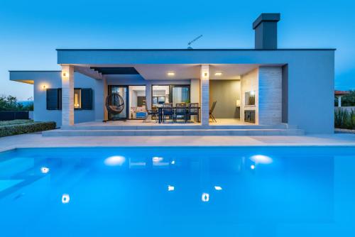 una casa con piscina frente a ella en Villa Lorena Dalmacija, en Nin