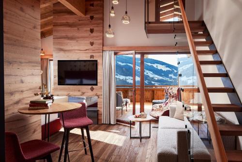 Habitación con escalera y sala de estar con vistas. en Der Böglerhof - pure nature spa resort, en Alpbach