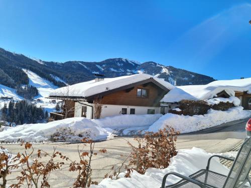 een huis bedekt met sneeuw met bergen op de achtergrond bij Hochkönig Ferien in Mühlbach am Hochkönig