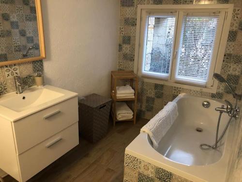 bagno con vasca bianca e lavandino di Appartement 2/3 pièces (55m²) au cœur du Vexin a Chars